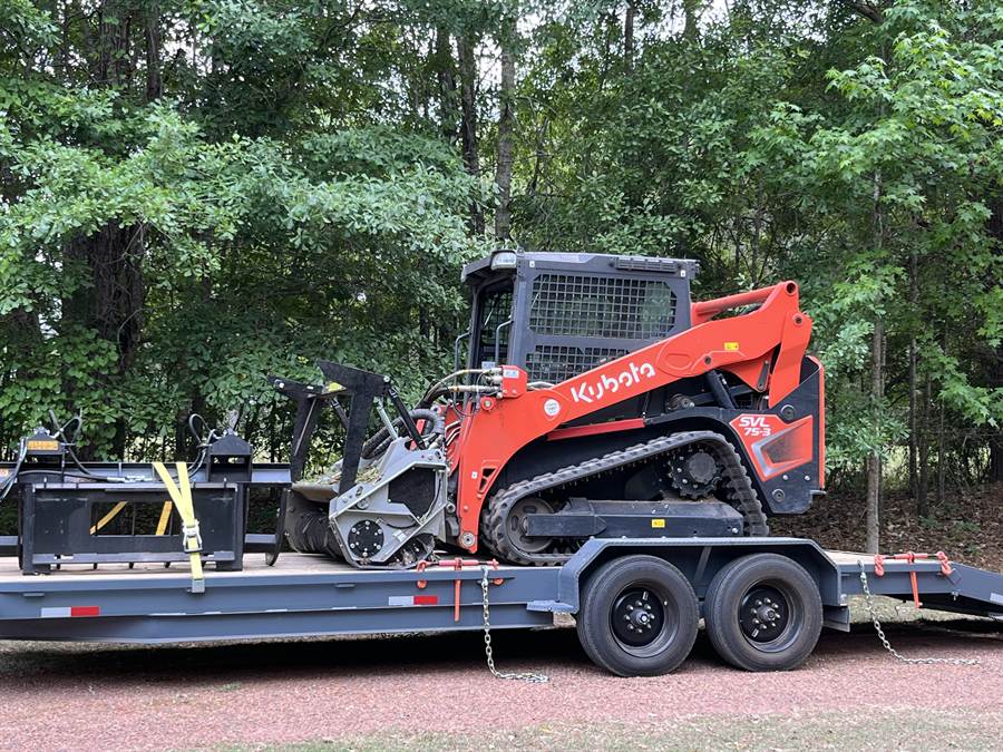 Kubota SVL 75-3 track loader with forestry mulching head on a trailer